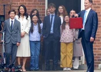 Jeremy Hunt’s wife and children make a rare public appearance as they watch the Chancellor hold up his red budget box outside Downing Street