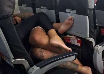 Plane passenger is left horrified by canoodling couple who spent entire four-hour flight SPOONING while lying down across a row of seats BAREFOOT