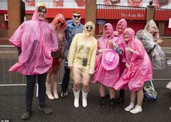 Taylor Swift thanks poncho-wearing Swifties for waiting hours in the rain as she takes to the stage at Anfield for her 100th Eras Tour show wearing pink bejewelled bodysuit