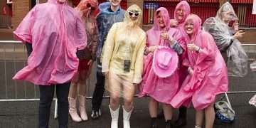 Taylor Swift thanks poncho-wearing Swifties for waiting hours in the rain as she takes to the stage at Anfield for her 100th Eras Tour show wearing pink bejewelled bodysuit
